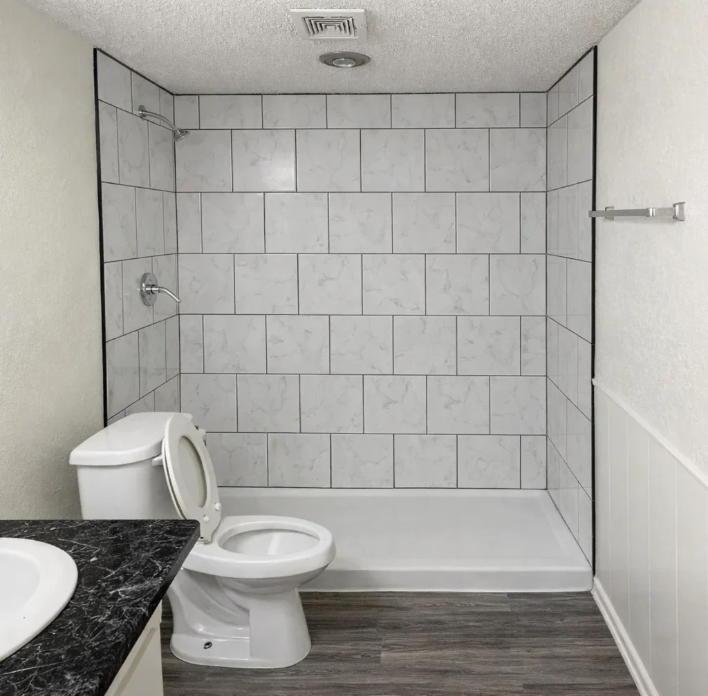Updated Bathrooms at La Villa Elms Modern bathroom with walk-in shower and marble-style tile at La Villa Elms Apartments in El Reno.